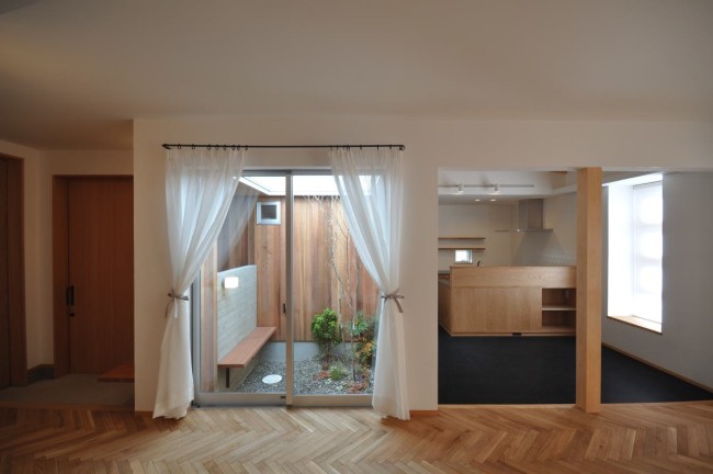 リビング。ヘリンボーン床と左官壁。